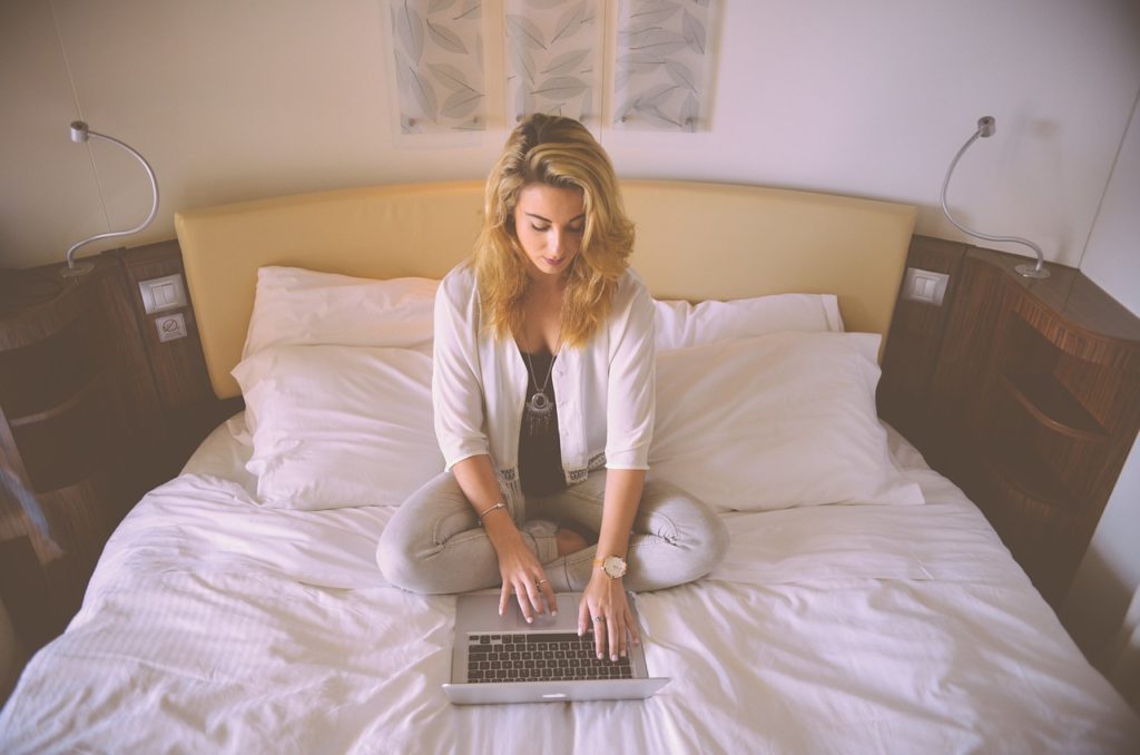 ベッドでパソコンを見る女性